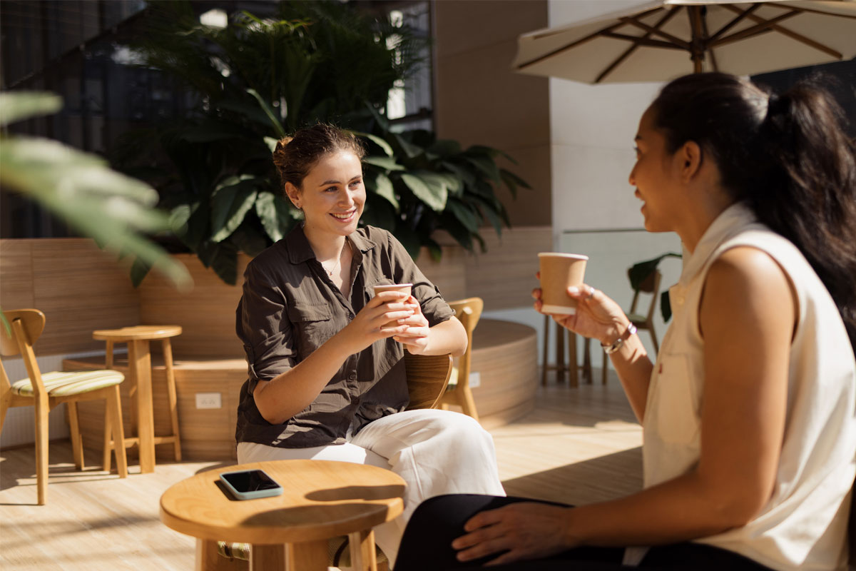 Two women having a conversation at a coffee shop