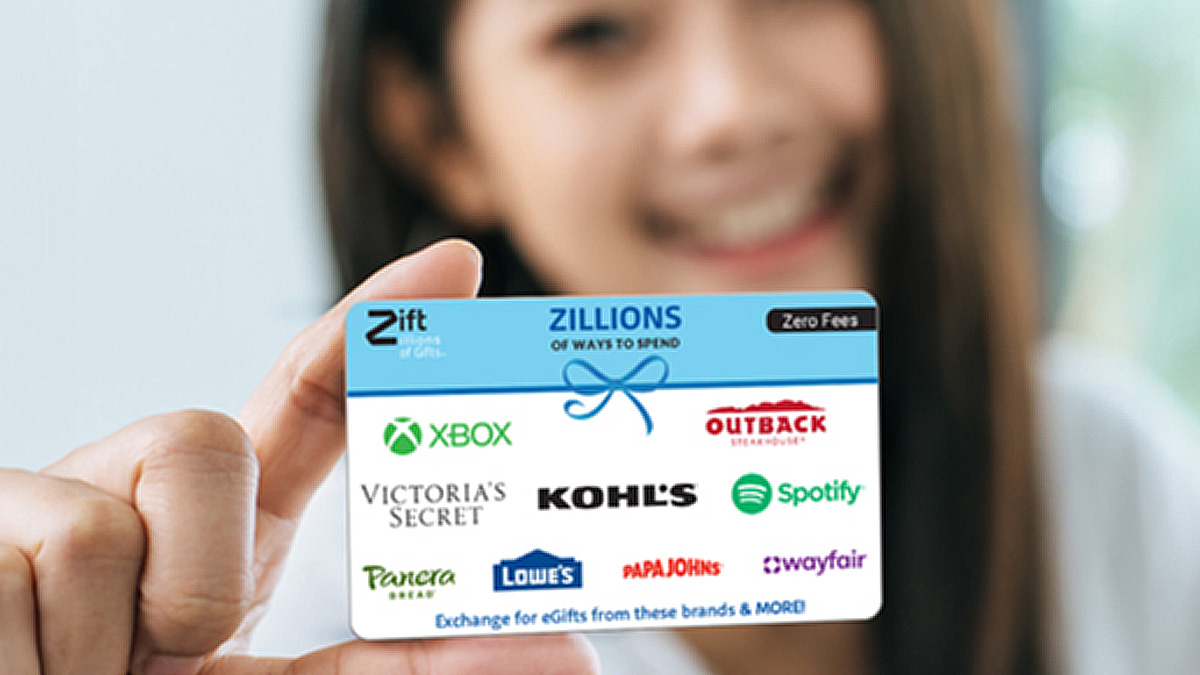 Woman holding a gift card with various brand names on it.