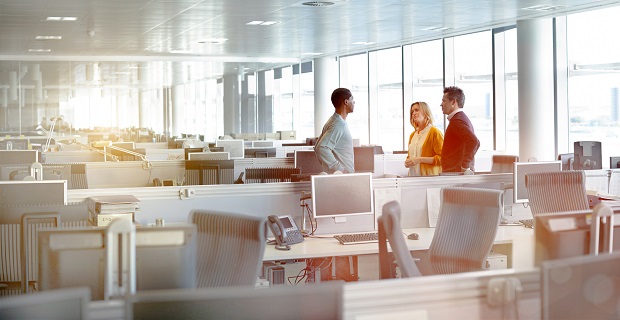 Three people standing in an office talking