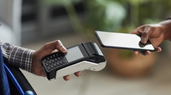 Person tapping a credit card issued by a Georgia commercial bank.