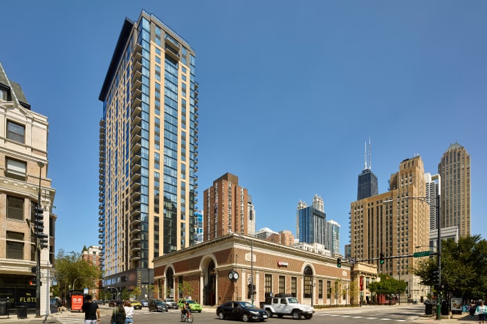 Outside view of a condominium tower and nearby buildings in a city.