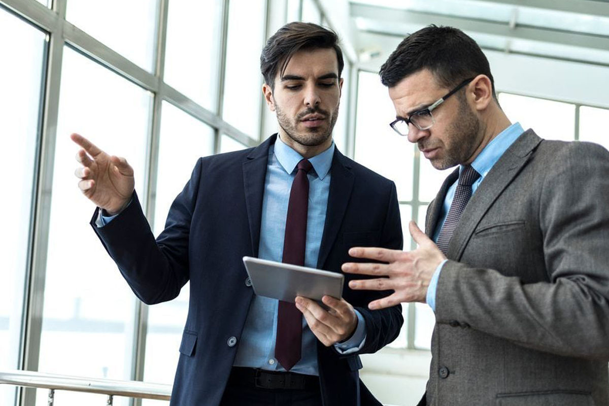 two business men having a discussion with a tablet