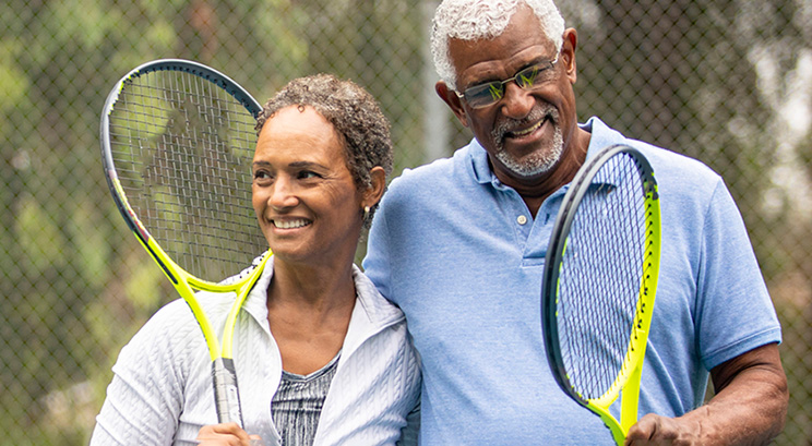 a couple walking off of a tennis court