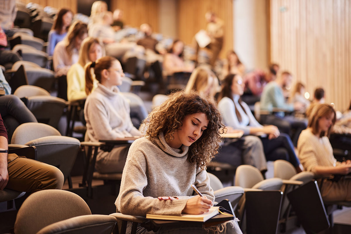 college student taking notes during class