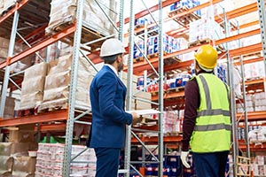 Two men wearing hardhats in a warehouse