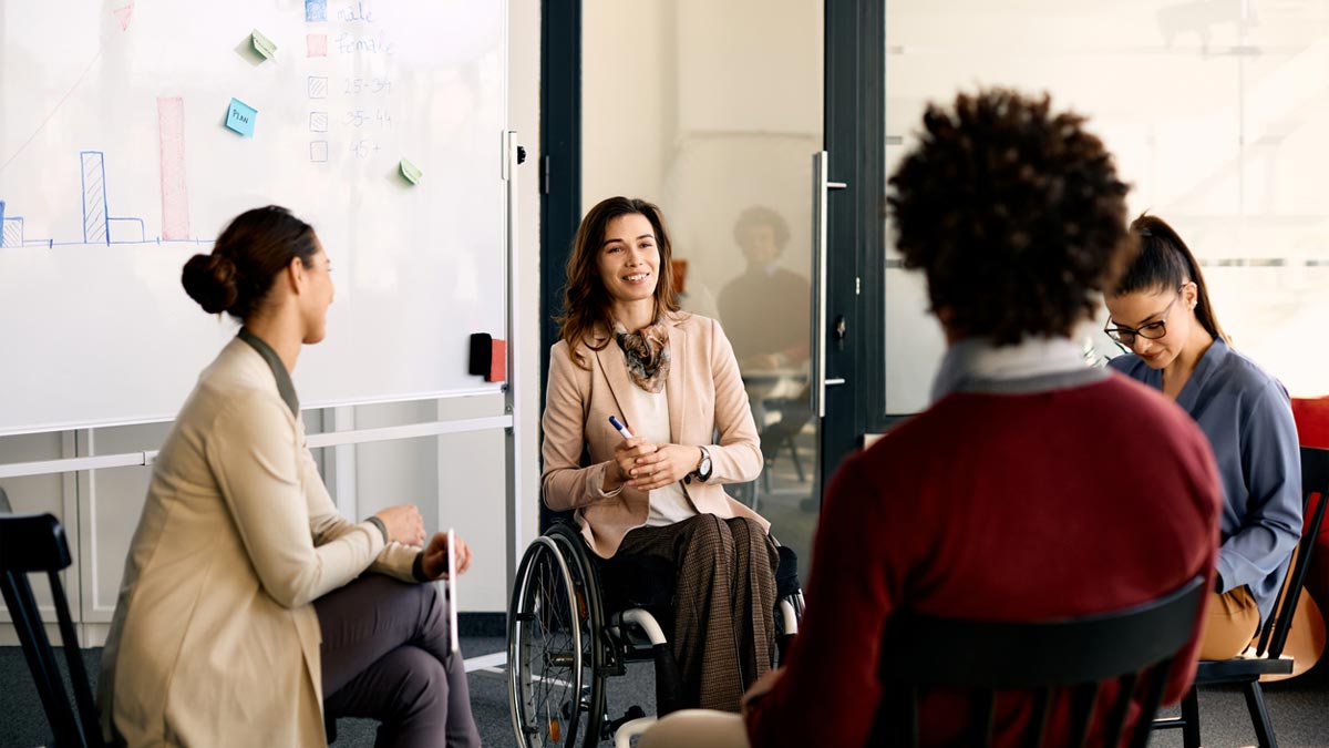 Group of employees chatting with one in a wheelchair