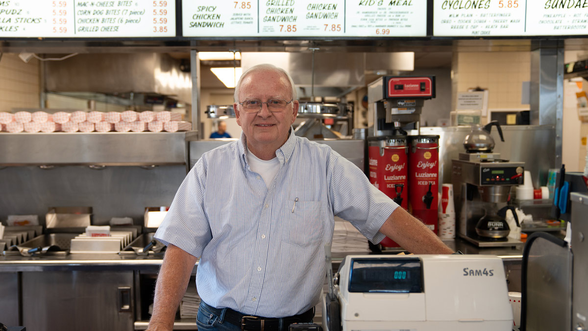 Man at counter of burger restaurant.