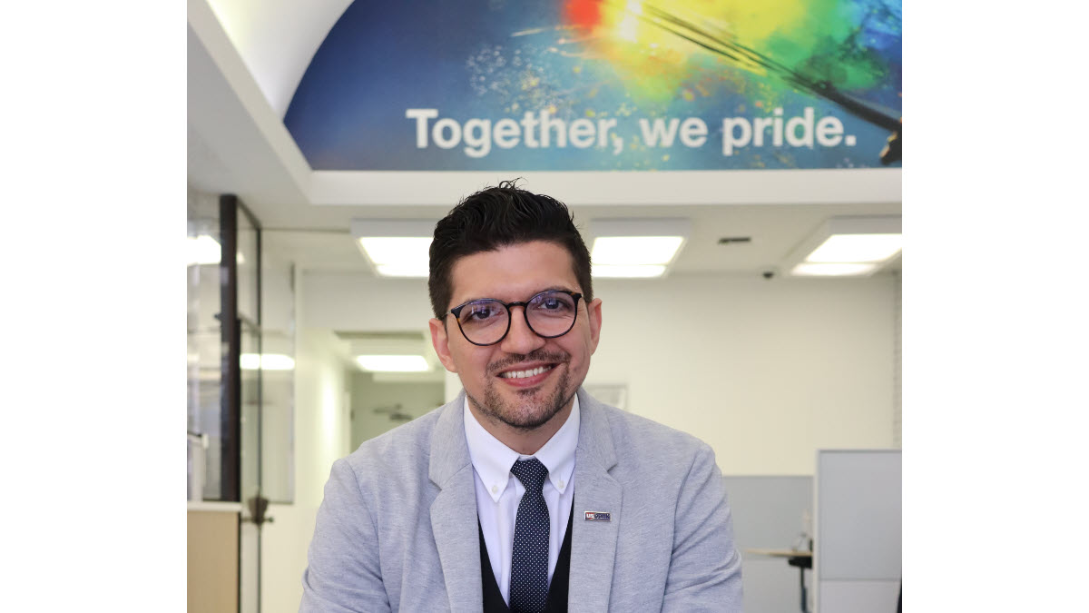 Marcus Almeida smiling at the LGBTQ flagship branch.