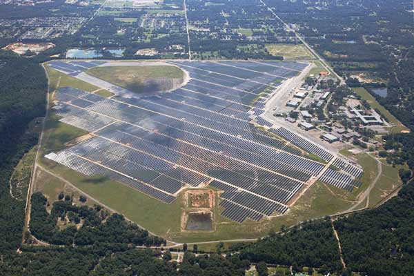 Aerial view of a large solar farm outside of a small town.
