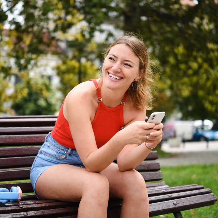 Student on bench with phone